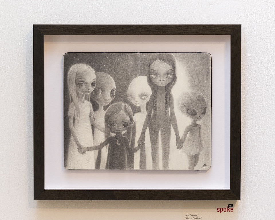 Ana Bagayan offers a framed black and white drawing on Moleskine paper, featuring six stylized, long-limbed hybrid children with large eyes and serene expressions, standing hand in hand against a minimal background that suggests night or a starry sky.