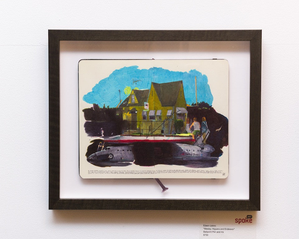 A framed artwork by Edwin Ushiro showcases a sketchbook page depicting a house under a blue sky. Below, two figures in ballpoint pen and ink sit on a submarine. Exhibited with the label Spoke at Spoke Art Gallery.