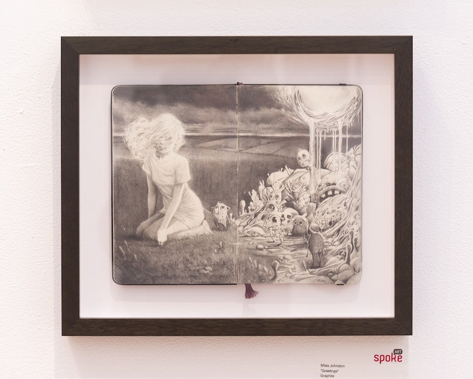 This intriguing framed artwork by Miles Johnston features a graphite illustration on Moleskine. The left shows a kneeling figure in a grassy field with clouds, while the right reveals a fantastical scene of swirling forms and creatures. Available for purchase.