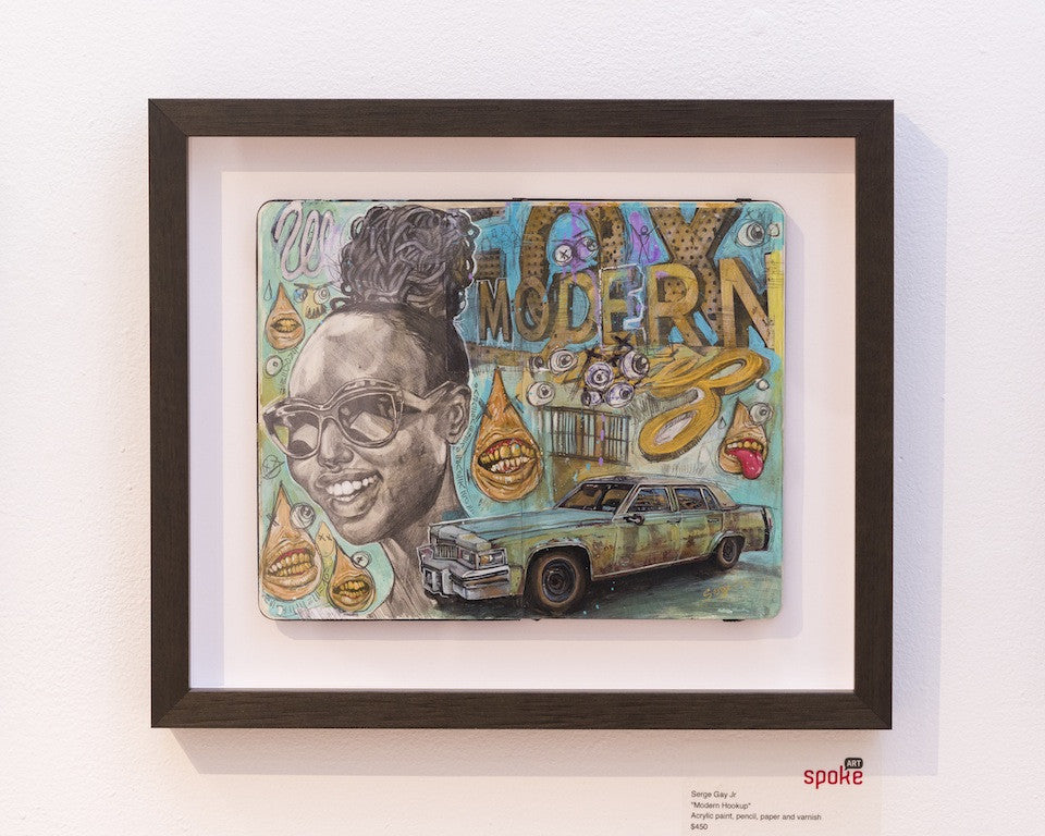A collage-style framed artwork by Serge Gay Jr. features a woman in sunglasses with an intricate hairstyle set against acrylic painting, a vintage car with MODERN text, and a background filled with patterns and abstract designs. A gallery label is at the bottom right.
