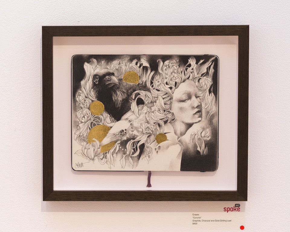A framed Craww artwork features a surreal scene with intricate graphite and charcoal line drawings. A womans face blends into flowing hair and animals, accented by gold gilding. It has a dark frame and a red dot on the gallery label.