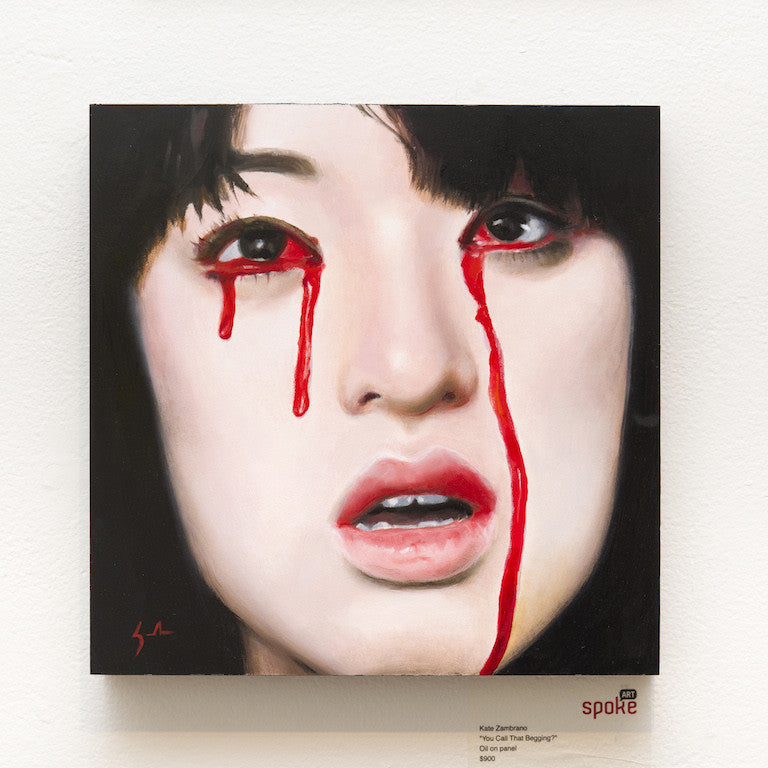An oil on panel by Kate Zambrano shows a woman with long dark hair, wide eyes, and a partially open mouth, with red streaks like tears on her cheeks. Its displayed on a white wall.