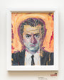 A vibrant Rich Pellegrino Acryla Gouache painting showcases a suited person against an orange background, with slicked-back hair and a serious expression. Displayed in a white frame, its mounted on the wall for exhibition.