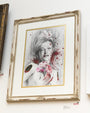 Mixed media artwork by Gene Guynn featuring a woman with roses, blending pencil sketches and red paint splatters, all set in an ornate distressed white frame.