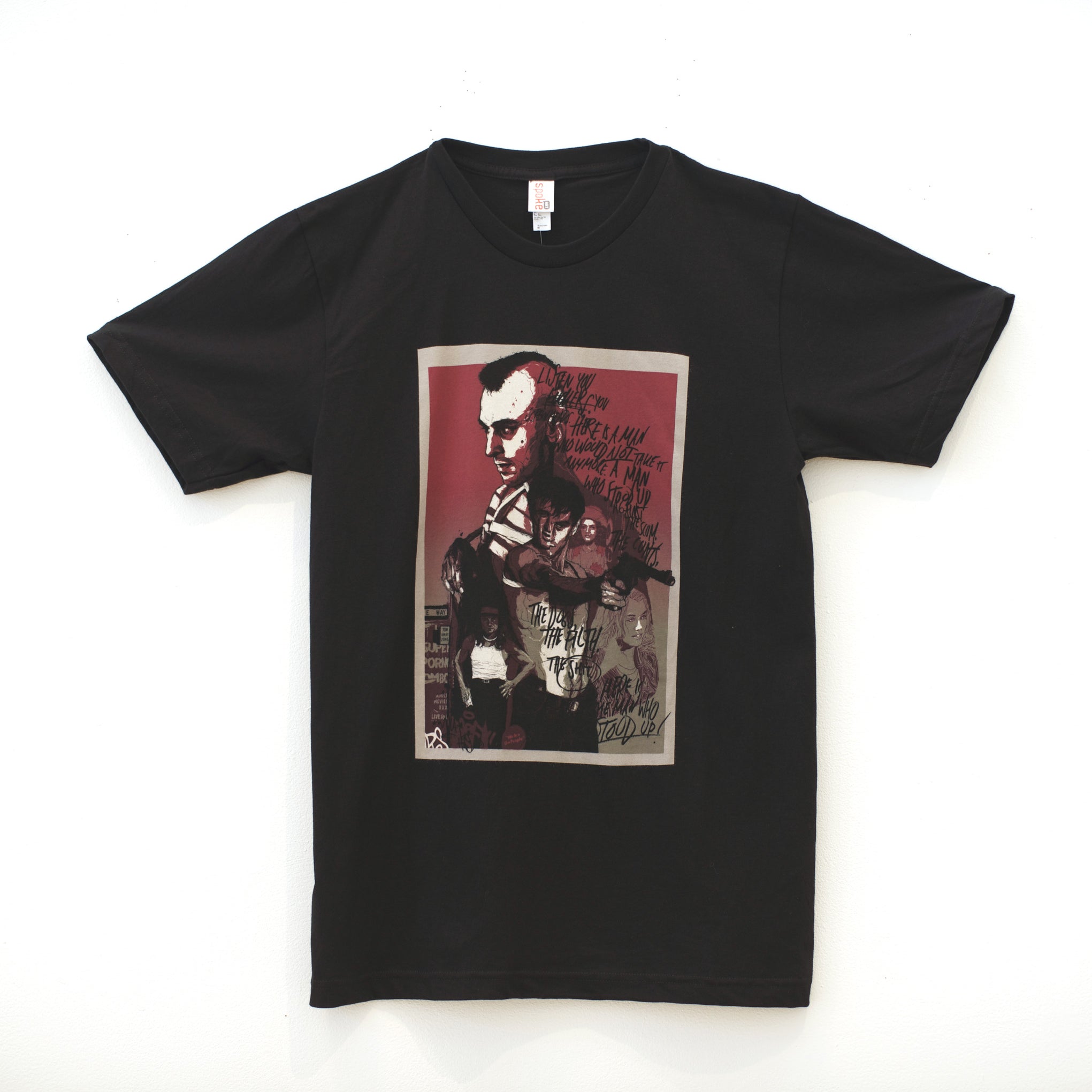Unisex black T-shirt by Grzegorz Domaradzki featuring a Taxi Driver-inspired graphic of a man in sunglasses with vibrant red, black, and white tones, text scribbles, and images of two other figures. Made from 100% cotton with a plain white background.