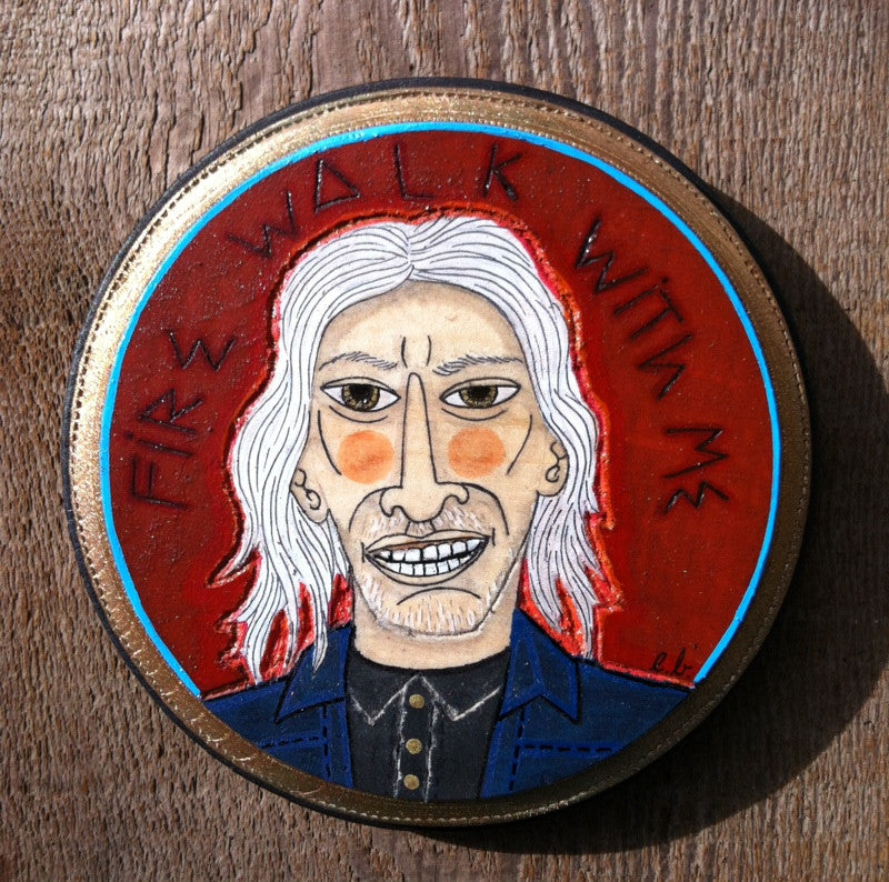 A circular mixed media artwork by Evan Harris showcases a caricature portrait with long white hair and a menacing expression. Set against a red background, FIRE WALK WITH ME frames the image, evoking Agent Coopers mysterious adventures.