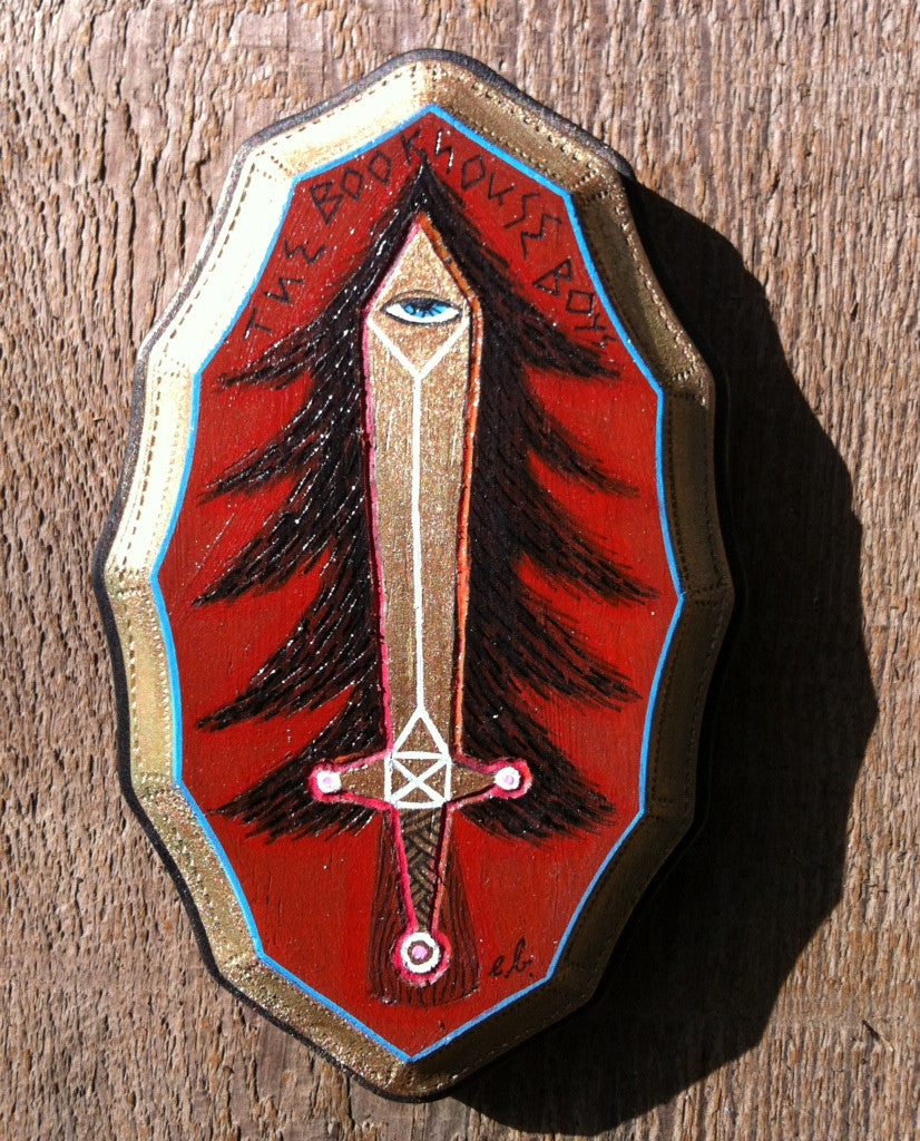 A decorative mixed media plaque by Evan Harris features a stylized sword topped with an eye on a red background, surrounded by a black tree-like pattern. THE BLOOD HOUSE BOYS is inscribed above the sword. The plaque has gold edges with a blue outline.