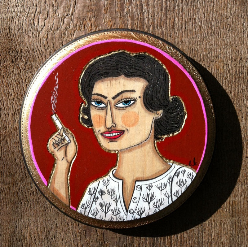 A painted portrait by the brand Evan Harris features a person with short black hair, a smirk, and a cigarette. Theyre wearing a white shirt with black tree patterns against a bold red backdrop. This mixed media artwork is crafted on a circular wooden surface.