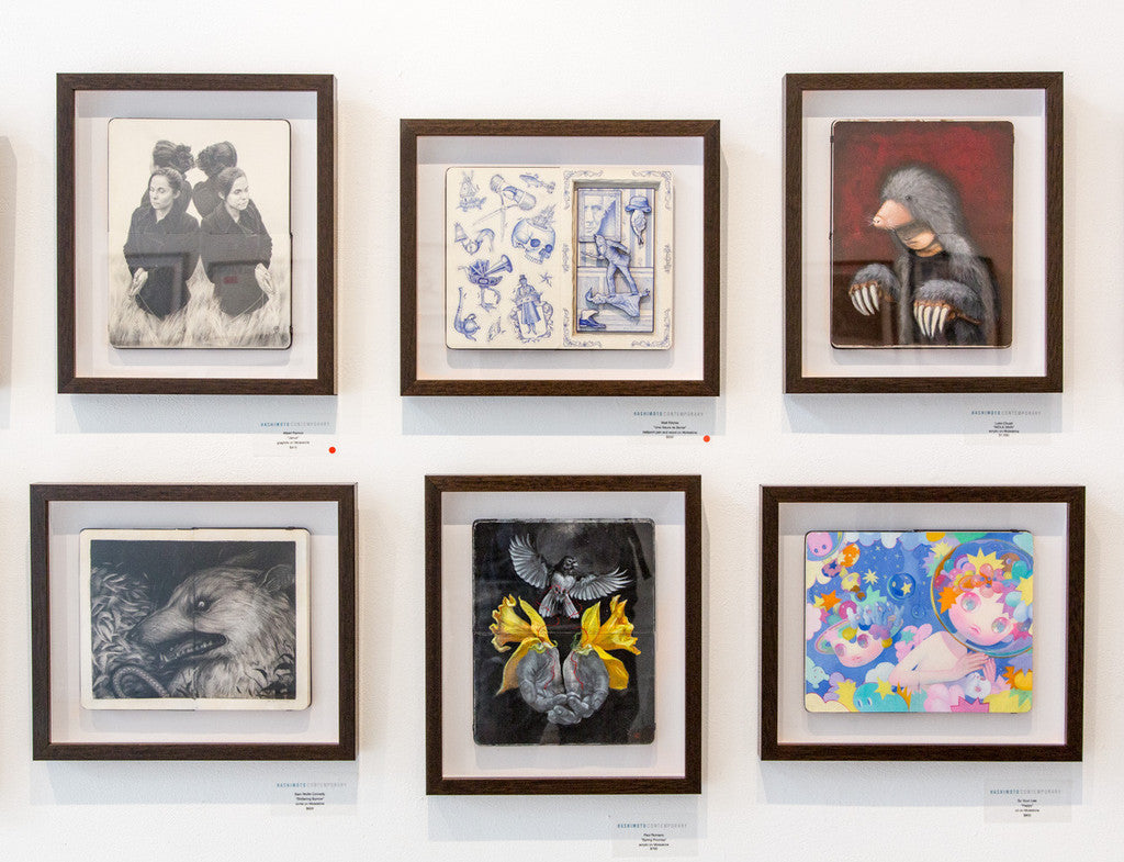 A wall showcases six So Youn Lee custom framed artworks with themes like monochrome figures, abstract designs, a mole, a feathered creature, an oil on Moleskine heart with birds, and a colorful cartoon-style piece featuring animals and stars. Payment plans available for collectors.