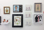 A gallery wall showcases diverse artworks like whimsical character sketches and paintings. Highlights feature a portrait reminiscent of Bobs Burgers, paired with Ana Aranda’s playful designs and conceptual illustrations on various frames and canvases.