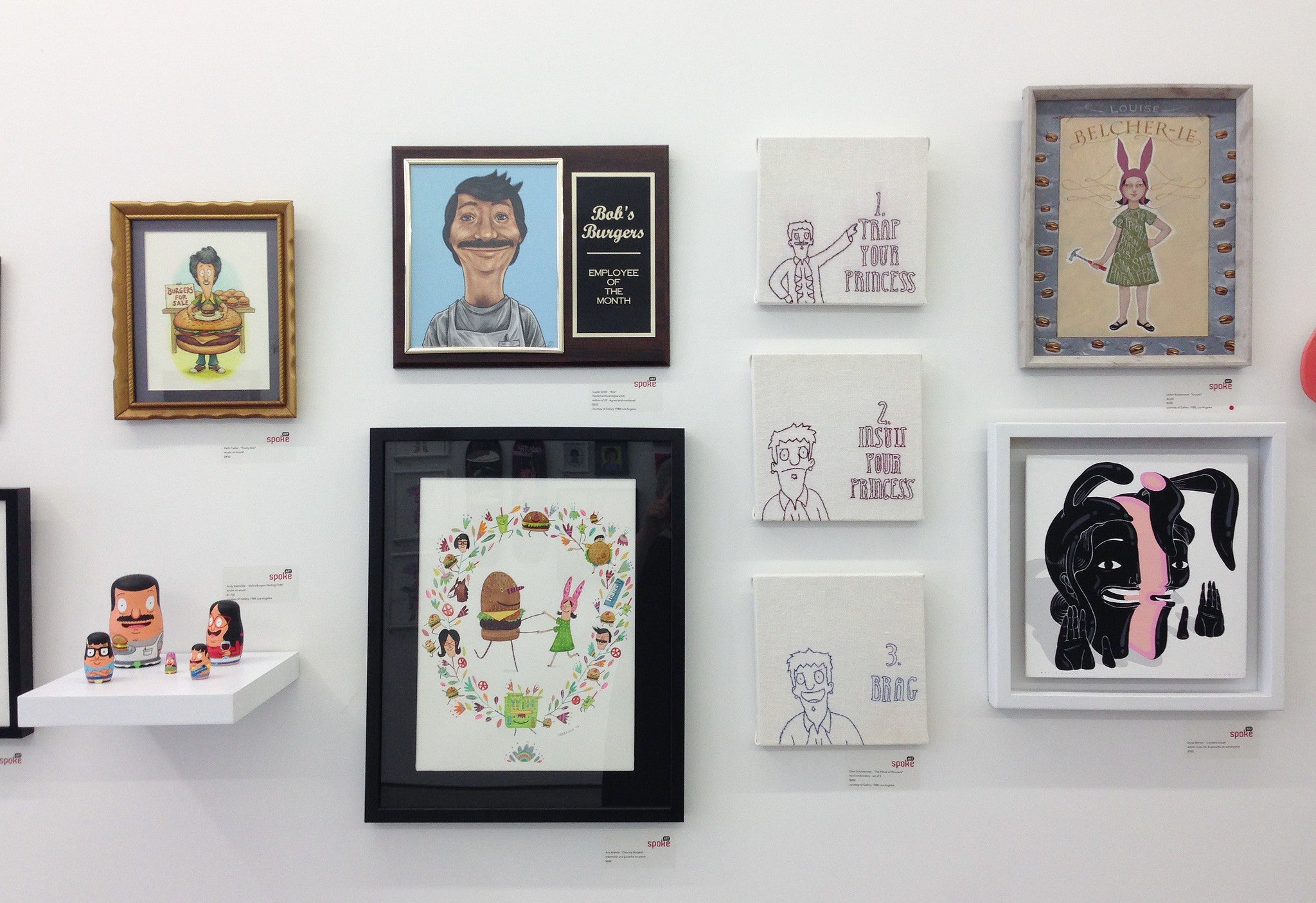 Gallery1988s art gallery features an eclectic display by Ellen Schinderman, showcasing cartoon illustrations reminiscent of a Bobs Burgers art show, unique character designs including a man with food, abstract figures, and diverse frames. Some works are enhanced with hand embroidery.