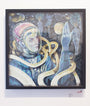 A framed artwork by Serge Gay Jr. features a futuristic figure in a spacesuit amid floating gold ribbons, surrounded by ethereal figures and celestial objects reminiscent of David Bowies Life on Mars, as the figure holds a glowing orb, gazing thoughtfully into the distance.