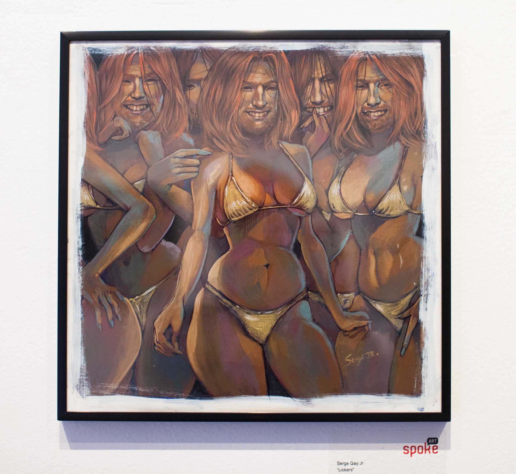 A Serge Gay Jr. painting of women with similar looks in bikinis, standing close together, features warm tones and exaggerated proportions. Displayed in a black frame on a white wall.