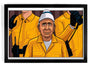 A Joshua Ellingson giclee print features three people in yellow uniforms and hats. Kumar, an older man, stands in front looking forward. Behind him are two figures with headsets and gloves holding radios. The print is elegantly framed in black.