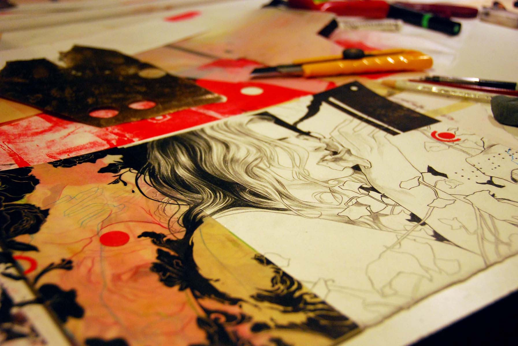 A close-up of an art project on a table showcases a detailed pencil drawing, echoing the style of Nimit Malavia, with a person amidst vivid abstract patterns and geometric shapes. Various drawing tools and papers are scattered around, inspiring creativity similar to pieces at Spoke Art Gallery.