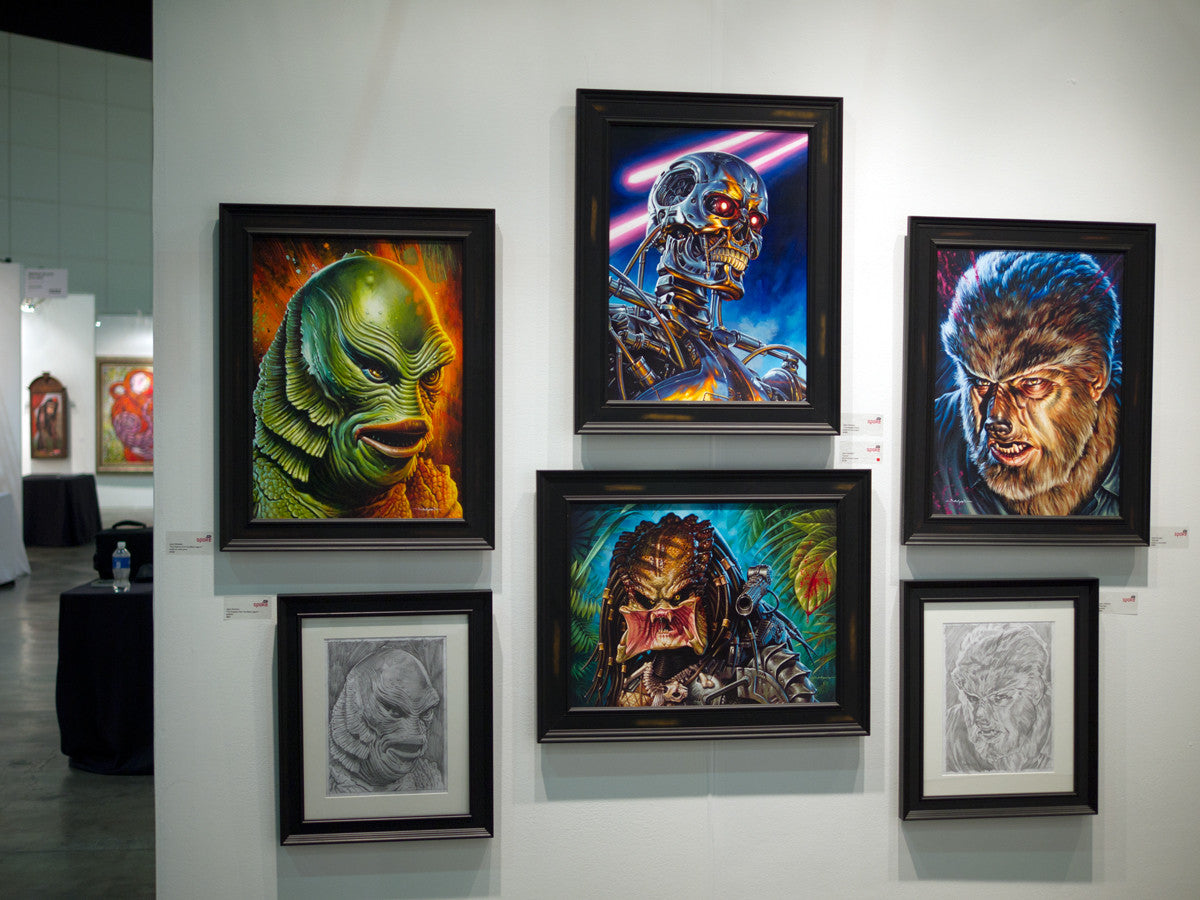 The art exhibit showcases framed paintings, including Jason Edmistons acrylic on wood panels of iconic sci-fi and horror characters like a robot, creature, and Wolf Man. Arranged elegantly in a structured display on a pristine white wall.