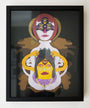 Framed abstract artwork by Daniel Jaffe showcases two stylized faces with bold colors and geometric shapes. The upper face exudes serenity, while the lower face is intense, featuring vibrant red, yellow, and purple details.