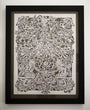 Elaine Penwells intricate white papercut art showcases symmetrical floral designs, animals, and butterflies, creating a harmonious and detailed menagerie against a dark background.