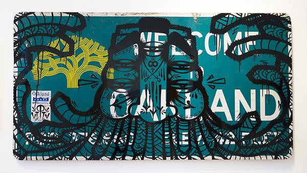 The image displays a street sign with intricate black and yellow designs inspired by octopus tentacles, capturing GATS unique style. A small sticker is visible in the lower left corner.