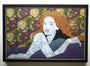 A captivating Chuck Sperry-inspired artwork showcases a red-haired woman lying on her side against a vibrant floral background. Her body and hair seamlessly merge with intricate patterns, creating a textured effect on an oak panel framed in black.