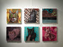 A wood panel by Casey Weldon displays six square cat paintings with diverse breeds and styles. Each artwork, rich in acrylic paint, features colorful backgrounds and varied poses, accompanied by a small label below.