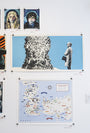 A wall features artworks: a digital print by Maria Suarez-Inclan showing a figure before a sword throne, striking portraits of two figures, and a detailed Westeros & Essos map echoing George R.R. Martins world with labeled locations.