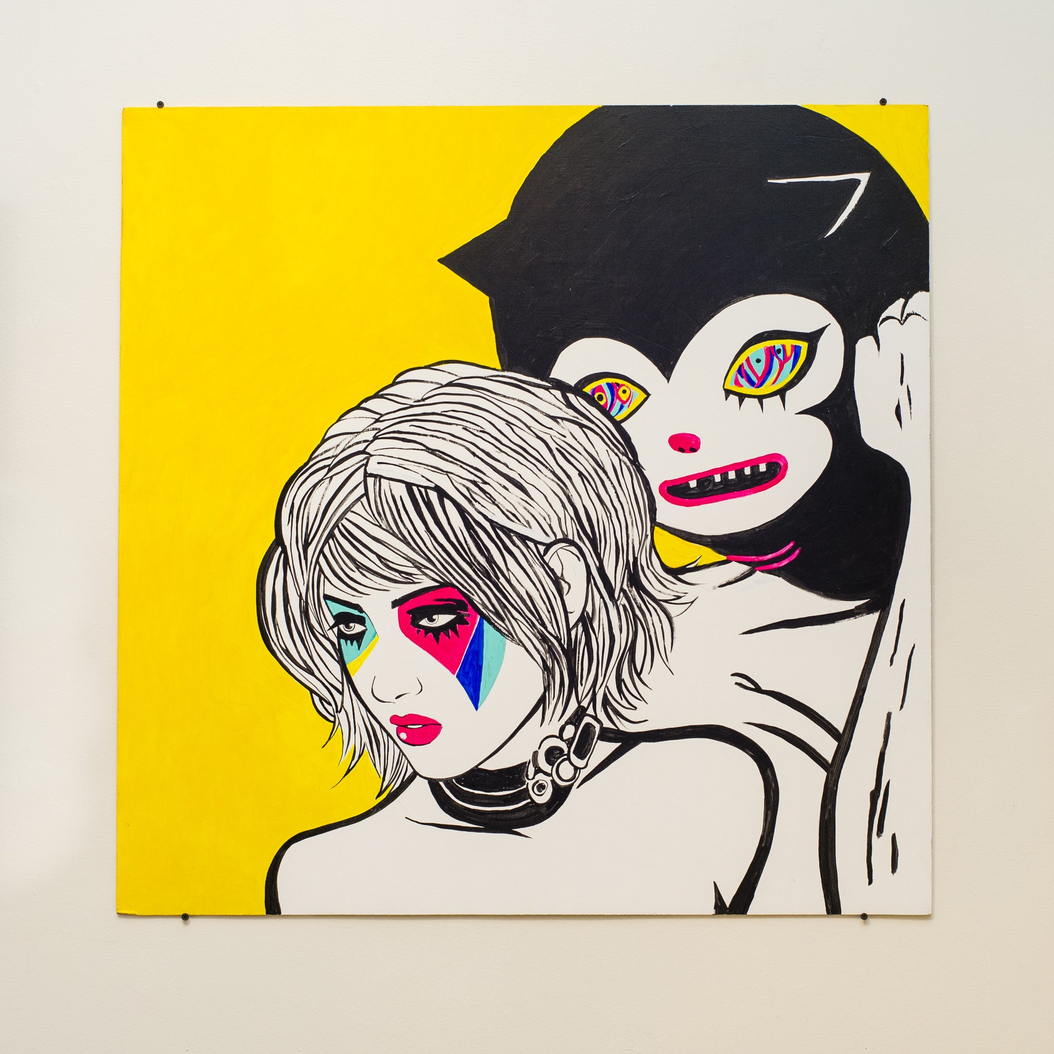 A vibrant Barnaby Ward artwork features two stylized figures on a bright yellow backdrop, one with colorful geometric face paint and the other resembling a cartoon character with multicolored eyes, playfully painted in acrylic on plywood.