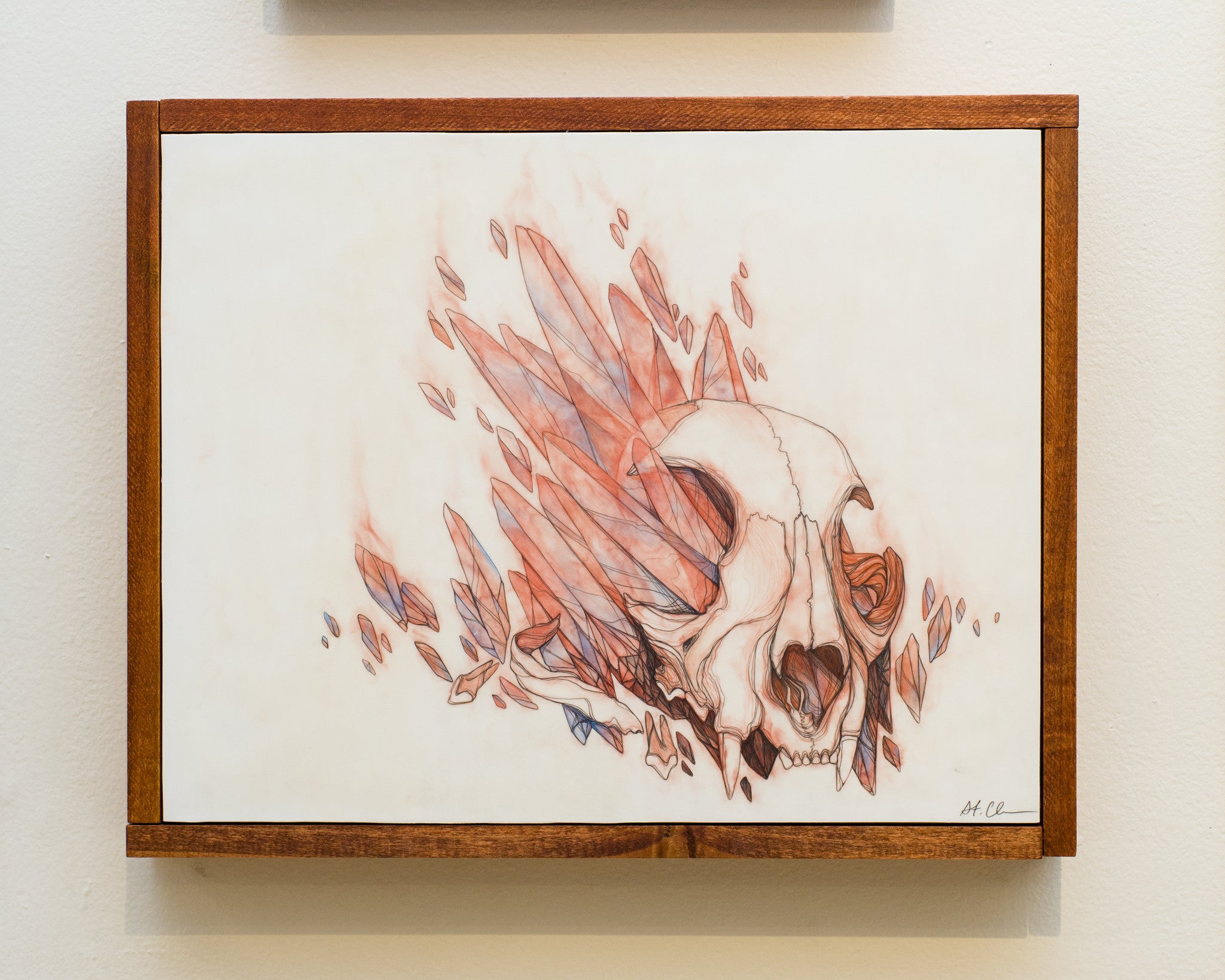 This breathtaking mixed media artwork by Tina St. Claire features a human skull surrounded by translucent red and blue crystals. Set against a light cream background, its elegantly framed in wood, blending realism with abstract elements masterfully.