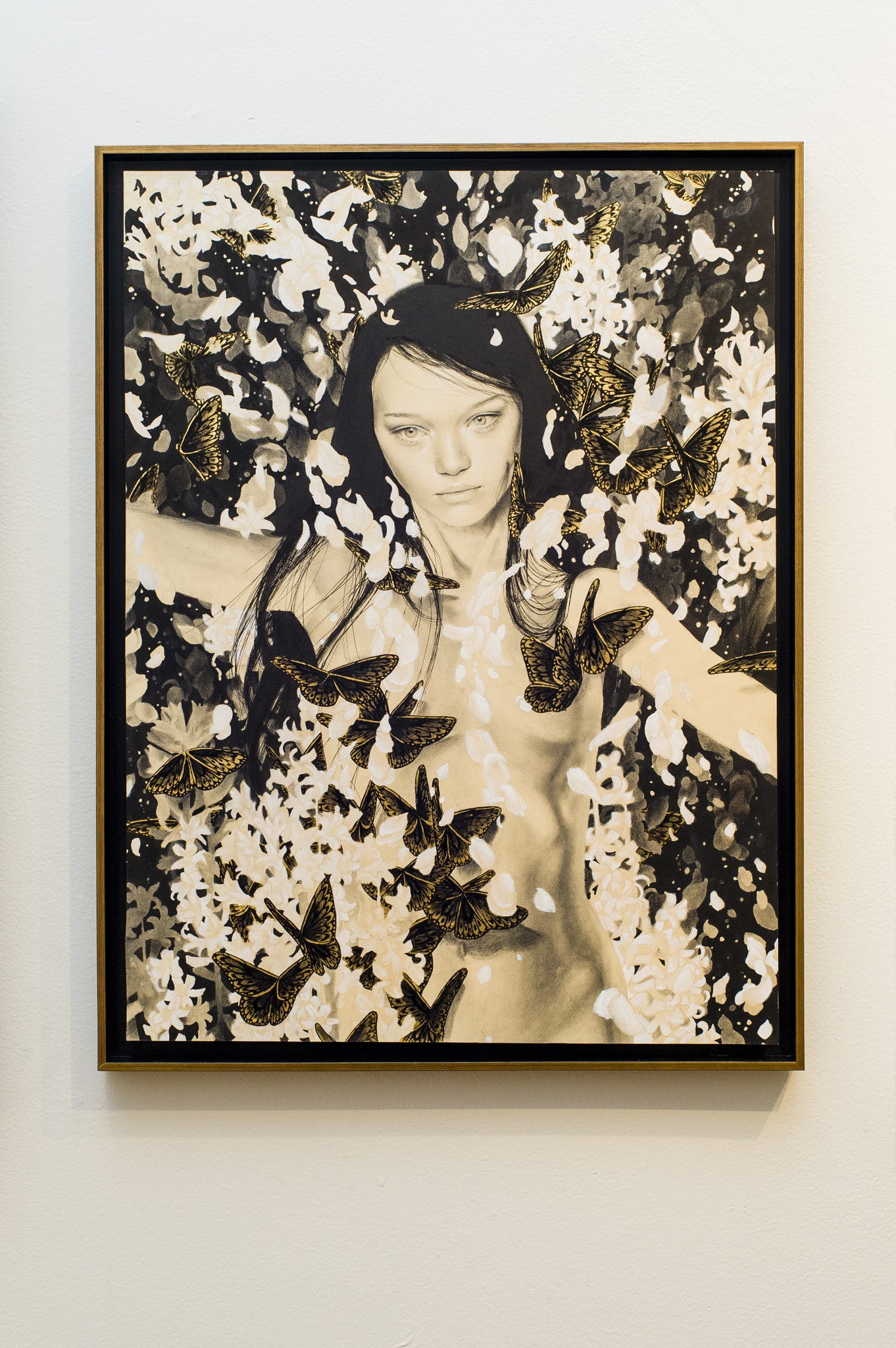 This Alessandra Maria framed art depicts a serene woman amid butterflies and abstract foliage, highlighted by dynamic swirling patterns in black, white, and gold leaf.