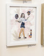 At Spoke Art Gallery, Steve Seeley presents an acrylic on paper piece showing a woman in a skirt and long-sleeve top juggling two floating heads with hats, with colorful blocks nearby. The labels on the wall provide the artists name and price details.