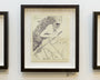 The artwork Lupus by Alex R. Kirzhner features a stylized woman with long hair and a feathered headdress, holding a spear alongside an outlined animal. Its priced at $10.