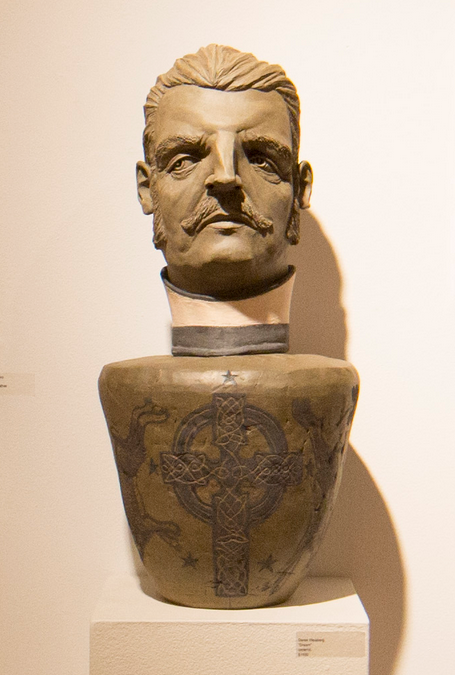 A well-lit gallery exhibits a Derek Weisberg ceramic artwork, featuring a mans bust with a mustache skillfully integrated into a vase adorned with Celtic-style engravings.