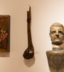 In a Martin Scorsese tribute art show, a museum displays Lucien Shapiros sculpted bust on a pedestal, a carved wooden club-like object, and an abstract painting. These artworks are thoughtfully mounted on a light-colored wall.