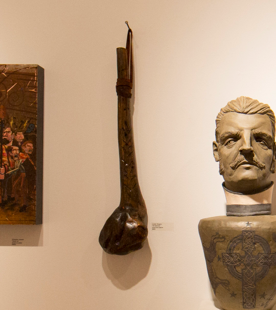 In a Martin Scorsese tribute art show, a museum displays Lucien Shapiros sculpted bust on a pedestal, a carved wooden club-like object, and an abstract painting. These artworks are thoughtfully mounted on a light-colored wall.