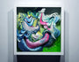 Crystal Wagners vibrant abstract art, inspired by Bio Interloper VI, showcases swirling patterns in blue, pink, green, and yellow. This dynamic piece captures the essence of a screen print and is elegantly framed in white against a plain wall.