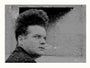 A man with dark, tall, and voluminous hair reminiscent of Henry Spencer intently stares sideways. The gritty overlay, similar to an Eraserhead screen print, adds a vintage touch. The plain wall accentuates his expression in this artistic portrait from the Tim Jordan brand.
