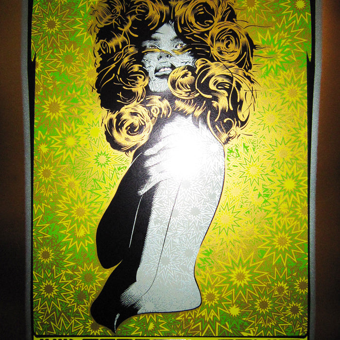 A Chuck Sperry silkscreen print features a vibrant Widespread Panic poster with an abstract woman on a yellow and green background, highlighting the bands March 2010 South Carolina shows.