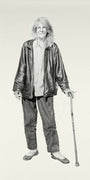 A pencil drawing of an elderly person with shoulder-length hair wearing a leather jacket, shirt, and pants while holding a cane. They stand facing forward with a gentle expression in the Joel Phillips style, echoing works displayed at Art Basel Miami Beach.