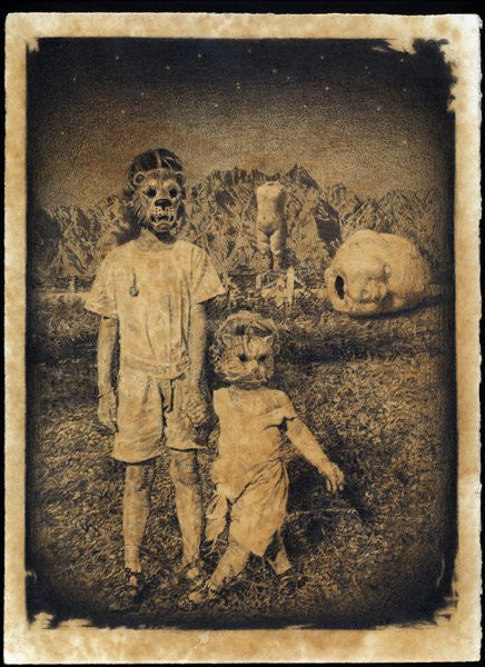 A sepia-toned image at Spoke Art Gallery portrays a surreal scene of two figures in animal masks on grass with mountains in the background. Enigmatic oversized objects, including a head resembling C3s graphite sculptures, are intriguingly positioned behind them.