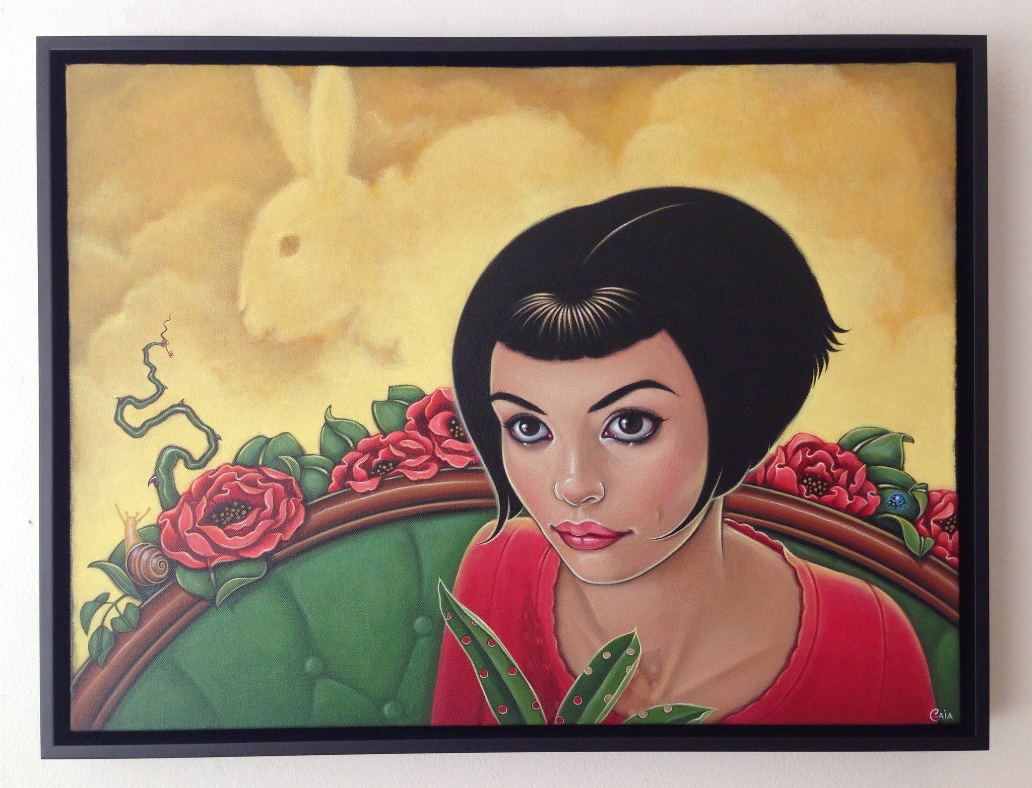 A Caia Koopman-style painting features a woman with short black hair and large eyes on a green chair amid red flowers. A rabbit silhouette dances against a yellow sky, as a small green figure peeks out playfully—acrylic on canvas captures this whimsical scene.