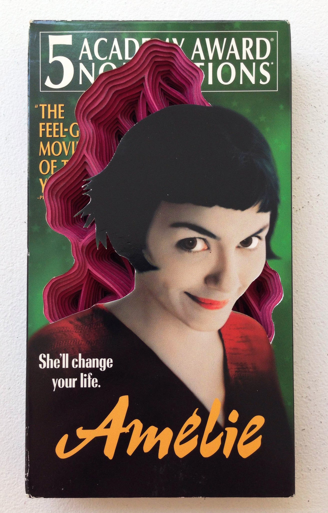 A Charles Clary stylized Amelie VHS cover features hand-cut paper art framing the leads face with black hair and red lips. The background highlights five Academy Award nominations and the tagline Shell change your life, all within a nostalgic VHS box.