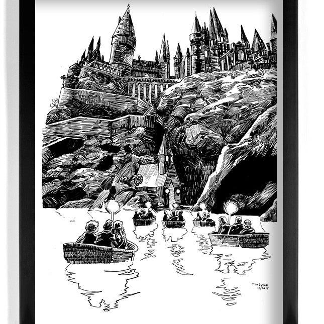 An original Tim Doyle pen and ink illustration depicts a castle on a cliff with tall spires reminiscent of a fantasy, akin to Hogwarts. Several small boats approach the shore below, creating an enchanting setting. The image is elegantly framed in black.