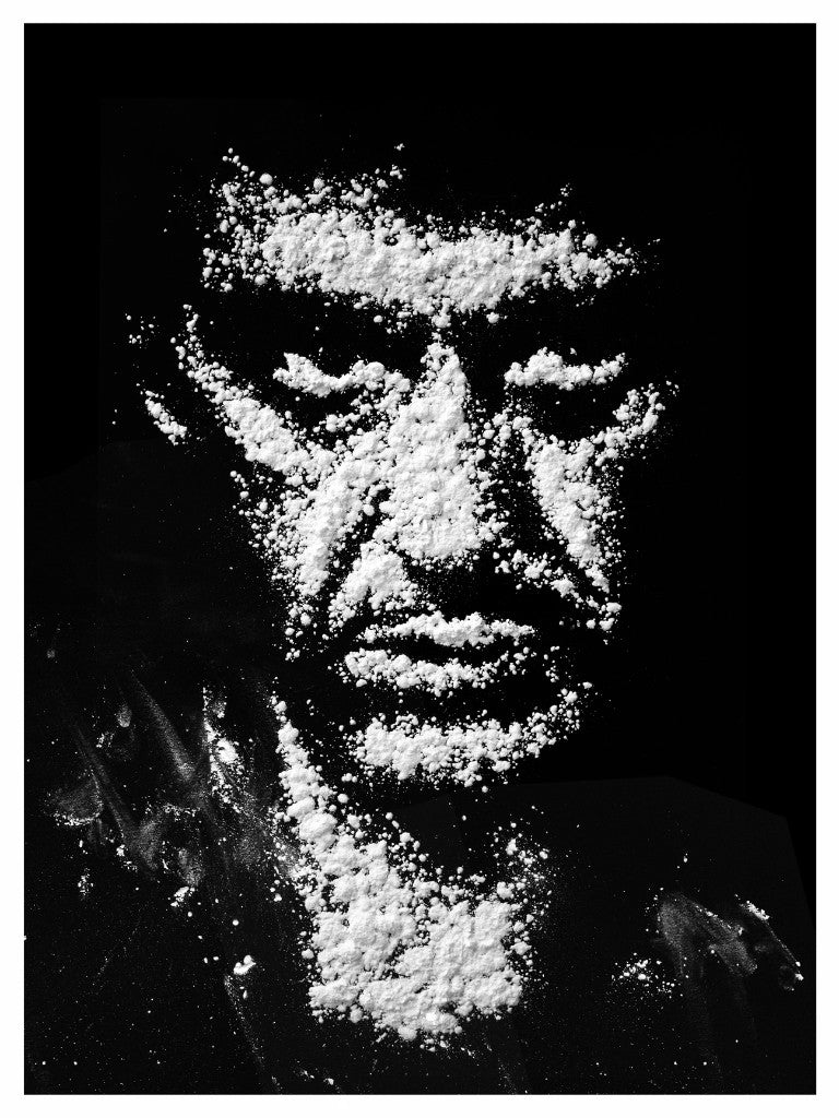 A persons portrait is crafted in white powder on a black background, echoing Alan Hynes style. This Scarface-like screen print forms striking facial features, capturing an artistic image with bold contrast.