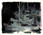 A Kim Cogan-style painting of docked boats at night features a harbor scene in dark, muted hues with indistinct details, capturing fishing vessels merging into the background and highlighting their silhouettes.