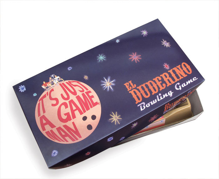 The Max Dalton El Duderino Bowling Game box displays a giant bowling ball and the phrase Its Just a Game, Man, with a small figure on top. Set against a dark background with colorful stars, this vintage game embodies laid-back fun.