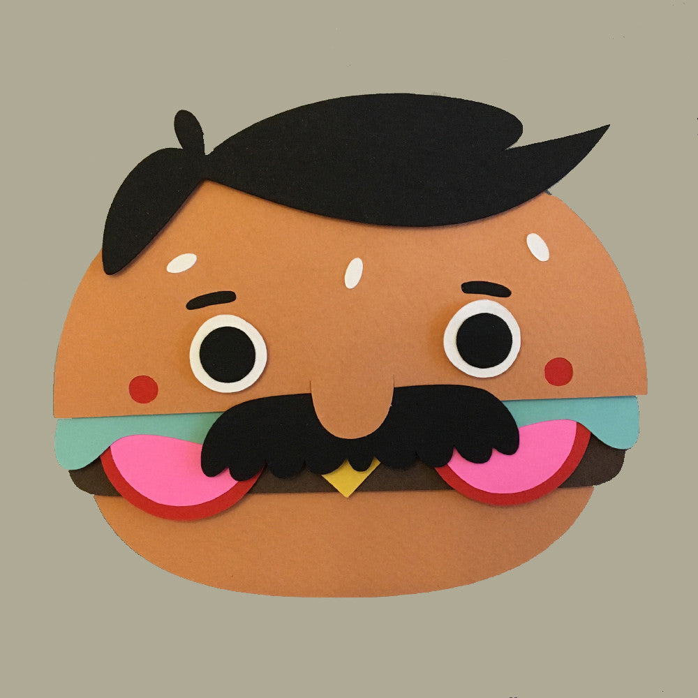 A cartoon hamburger by Michelle Romo displays a Bobs Burgers-inspired quirky charm with big eyes, a black mustache, colorful layers creating a mouth below bun eyebrows and hair-like top, all set against a plain gray background.