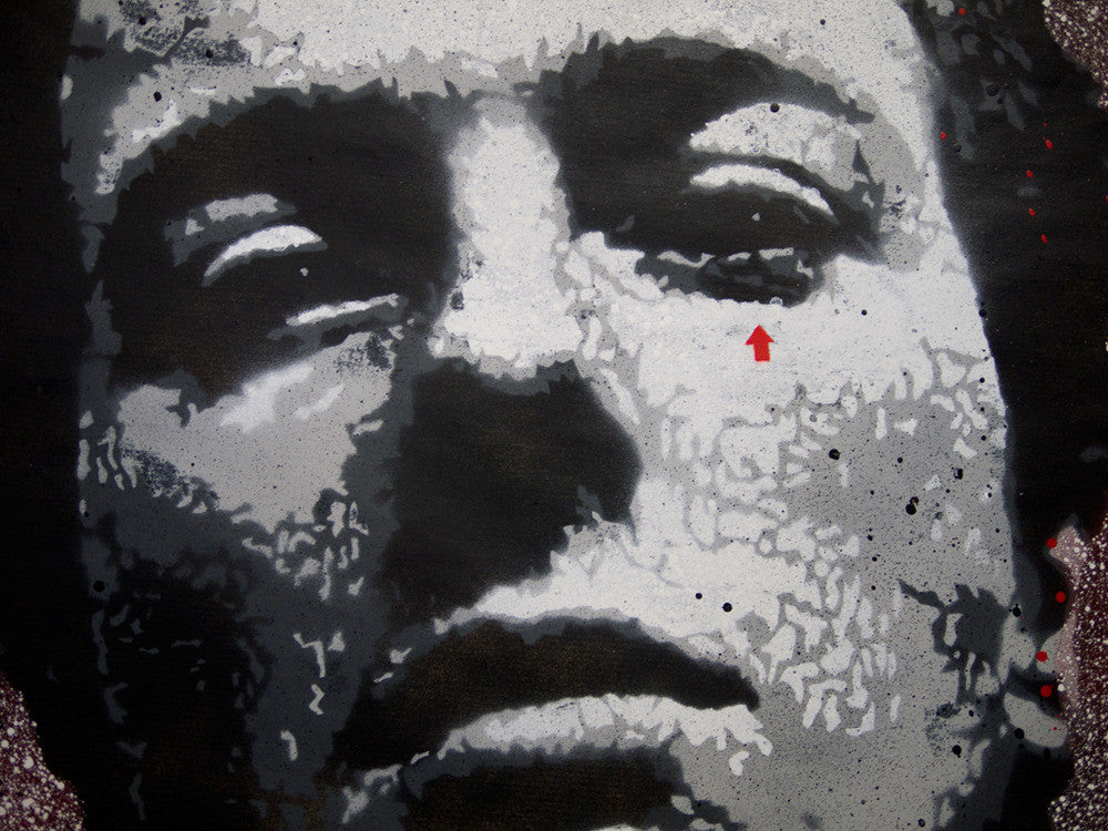 Close-up of a Jef Aérosol black and white graffiti portrait with abstract textures, featuring a detailed face resembling Joe Strummer. A unique red arrow stencil points to one eye, adding an original touch.