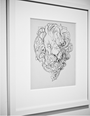 A framed black and white sketch of an abstract lions head with a swirling mane, reminiscent of the Nimit Malavia style, is mounted on a wall. The expressive linework resembles intricate acrylic on paper artwork.