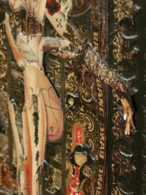 This mixed media collage by Handiedan showcases a vintage aesthetic with layered textures, featuring cutouts of tattooed legs and arms. It includes ornate patterns and text within an antique frame, complete with a small cartoon figure at the bottom.
