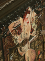A Handiedan artwork showcases a tattooed woman with red hair, surrounded by intricate patterns in a mixed media collage. Her tattoos feature symbols and text, enhancing the vintage style framed in an antique frame.